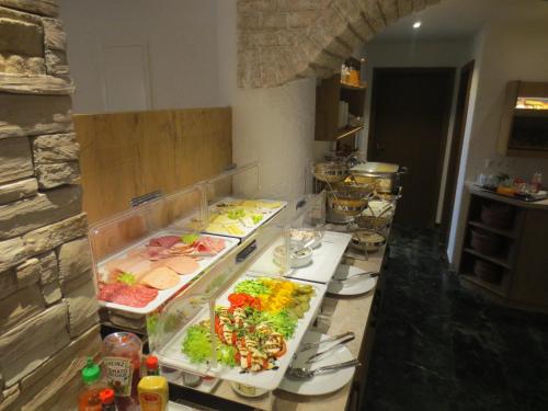 a kitchen with several trays of food on a counter at Hotel Alp Inn - Chiemgaukarte inclusive in Ruhpolding