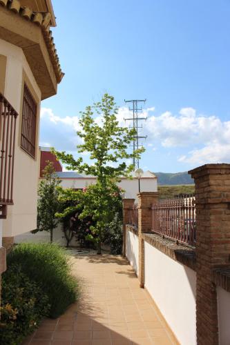 un balcón de una casa con una valla y un árbol en Villa Rural Campillo de Arenas, en Campillo de Arenas