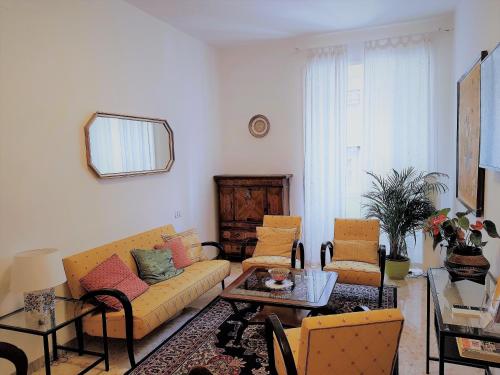 a living room with a yellow couch and chairs at EnzHouse in Rome