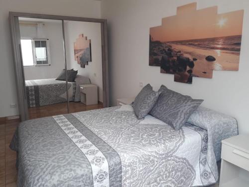 a bedroom with a large bed and a mirror at Casa Olivina 2 in Puerto del Carmen