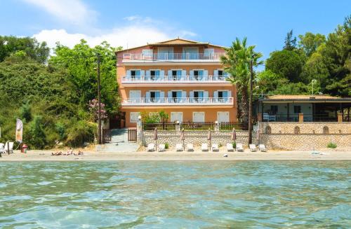 a building on the beach in front of the water at Nel Mare Studios in Laganas