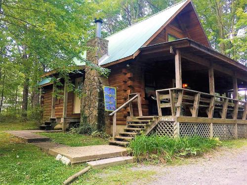 a log cabin with a porch and stairs to it at Country Road Cabins in Hico