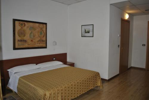 a bedroom with a bed and a picture on the wall at Albergo Al Viale in Trieste