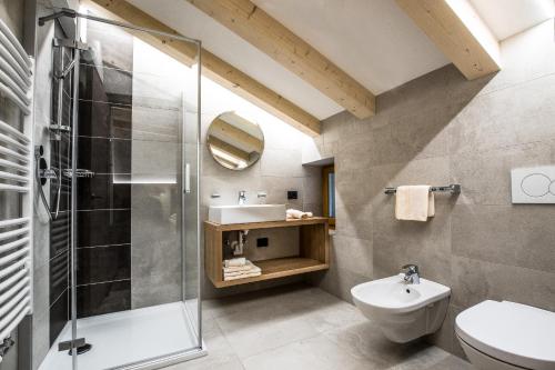 Un baño con ducha, inodoro y lavabo. en Residence Crazzolara, en La Villa