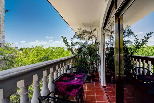 een balkon met stoelen en potplanten bij Suites Corazon in Playa del Carmen