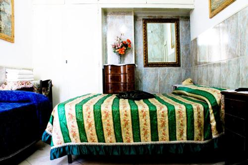 a bedroom with a bed with a green and yellow blanket at Hotel Stadler 2 in Rome