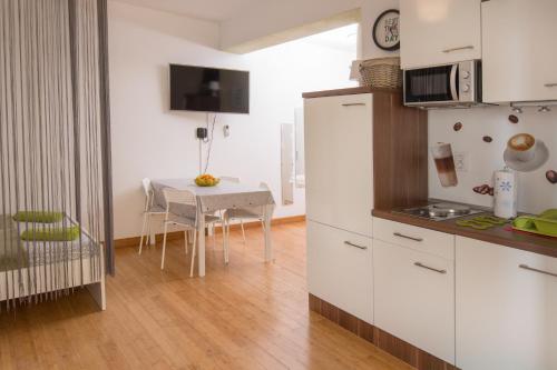 uma cozinha com uma mesa e um frigorífico branco em Apartment Nina em Pula