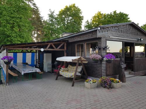a small shed with a table and chairs and flowers at Nina puhkemaja in Nina