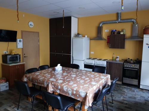 a kitchen with a table and chairs and a kitchen with yellow walls at Nina puhkemaja in Nina
