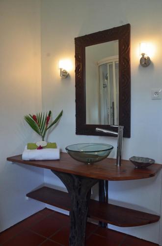 a bathroom with a sink and a mirror on a table at Gîte Case Dentelle in Le Diamant