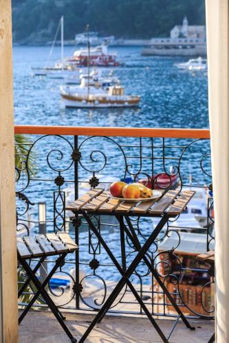 a table on a balcony with a view of the water at Seafront rooms Koluna in Komiža