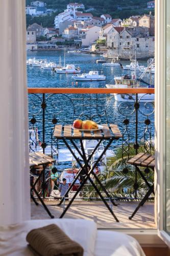 a balcony with a table and a view of the water at Seafront rooms Koluna in Komiža