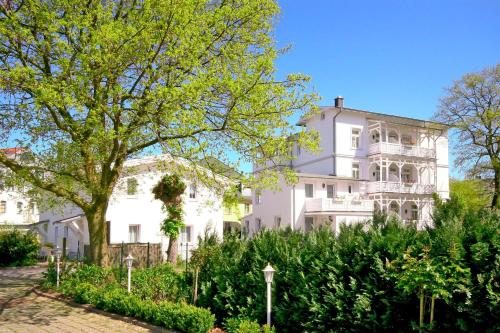 a white house with a tree in front of it at Hotel Garni Getreuer Eckart in Binz