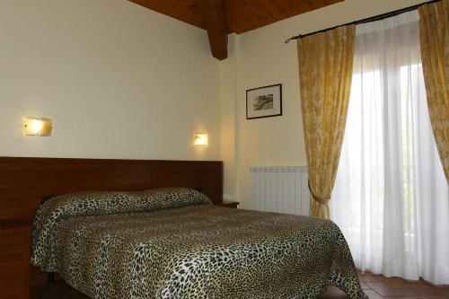 Villa Montotto في Monterubbiano: غرفة نوم بسرير ونافذة كبيرة