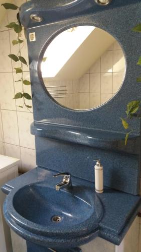 バラトンボグラールにあるMaci-Lak Apartmanのバスルーム(青いシンク、鏡付)