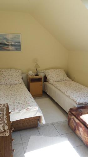 バラトンボグラールにあるMaci-Lak Apartmanのベッドルーム1室(ベッド2台、ナイトスタンド付)