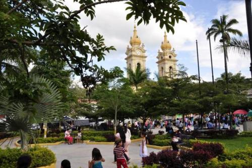 a group of people walking around a park with two towers at Hotel El Ganadero in El Total