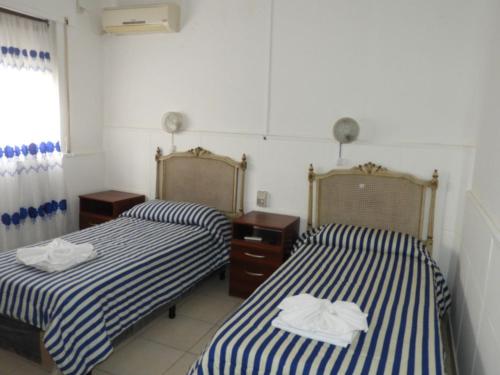 Dos camas en una habitación con toallas. en Hotel Mar Del Plata en Termas de Río Hondo