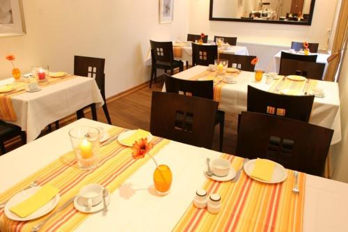 a dining room with tables and chairs with white tablecloths at Hotel Restaurant Rothkopf in Euskirchen