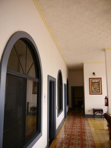 an empty hallway with an arched door and a rug at Hotel Santo Tomas / Historical Property in San José