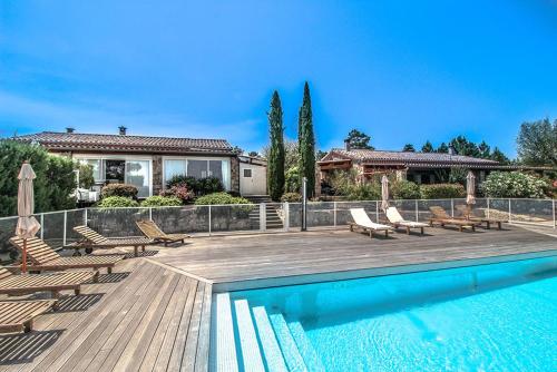 een zwembad met stoelen en een huis bij Les Clèdes du Mazel in Banne