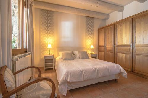 een slaapkamer met een wit bed en een raam bij Les Clèdes du Mazel in Banne