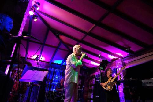 a man standing on a stage holding a microphone at Villa del Sueño in Playa Hermosa