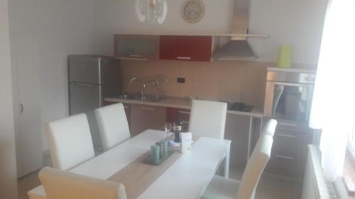 a kitchen with a white table and chairs in a kitchen at App. Adriatic Aurora in Umag