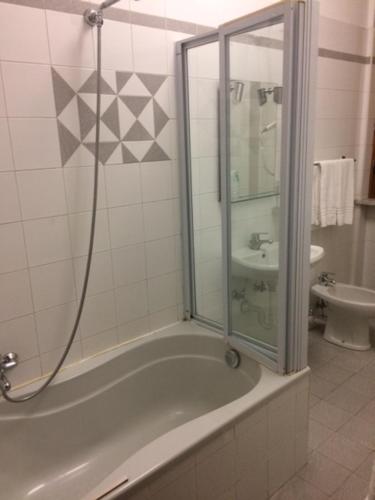 a bathroom with a shower and a tub with a sink at Twelve Hotel in Moncalieri