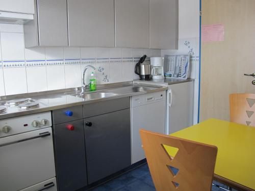 a small kitchen with a sink and a refrigerator at Artist Apartments & Hotel Garni in Zermatt