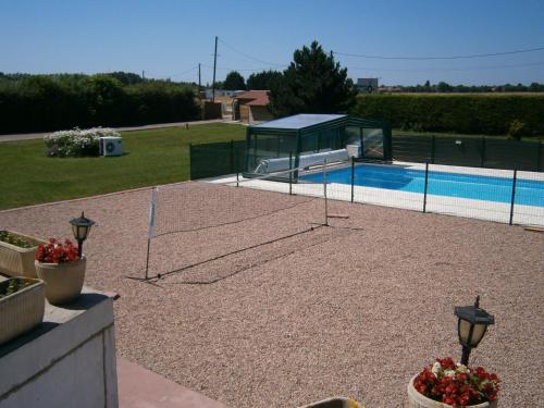 a pool with a volleyball net in a yard at L'Escale de la Baie de Somme in Le Crotoy