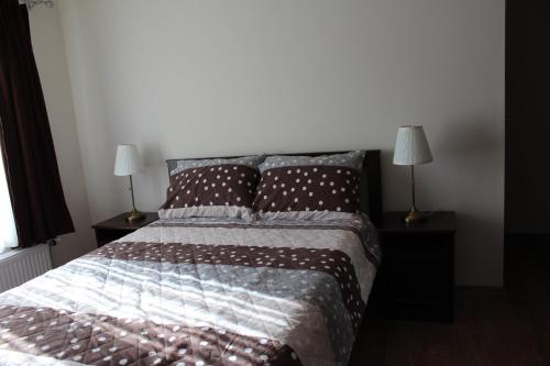 a bedroom with a bed with two lamps on tables at Emma Apartments in Bitola