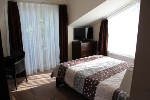 a bedroom with a bed and a tv and a window at Emma Apartments in Bitola