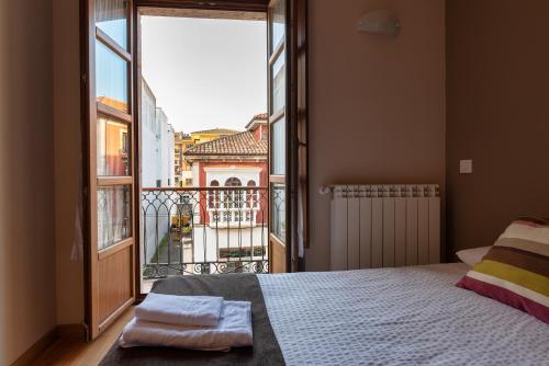 1 dormitorio con cama y ventana grande en Mirando Llanes A B C, en Llanes