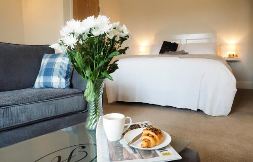 a vase of flowers and a plate of food on a table at The Horngarth in Whitby