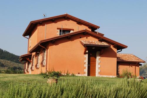 a building in a field next to a field of grass at Tenuta Del Perugino in Bettona