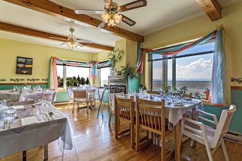 - un restaurant avec des tables et des chaises offrant une vue sur l'océan dans l'établissement Auberge de L'Anse, à Rivière-du-Loup