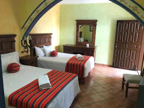 Cette chambre comprend 2 lits et un miroir. dans l'établissement Los Ángeles Hotel, à Jalpan de Serra