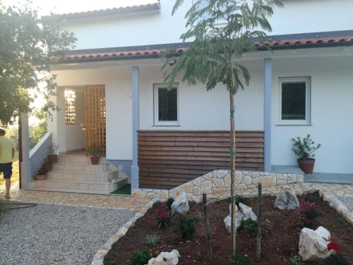 a house with a palm tree in front of it at Apartments Milena in Pinezici