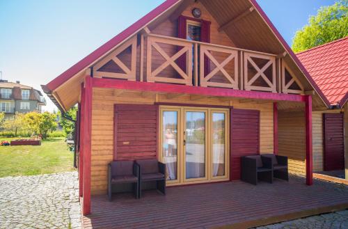 a small house with two chairs on a deck at Villa Amber in Sarbinowo