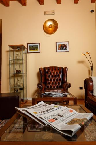 a living room with a chair and a glass table at Albergo Orologio in Brescia