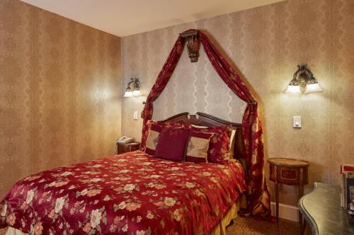 a bedroom with a red bed with a canopy at Queen Anne in San Francisco