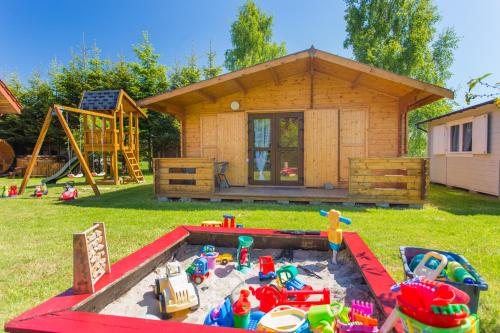 a childs play area with toys in a sandbox at Villa Amber in Sarbinowo