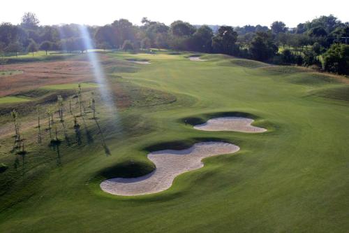 an aerial view of a golf course with a hole at Mercure Bayeux Omaha Beach in Port-en-Bessin-Huppain
