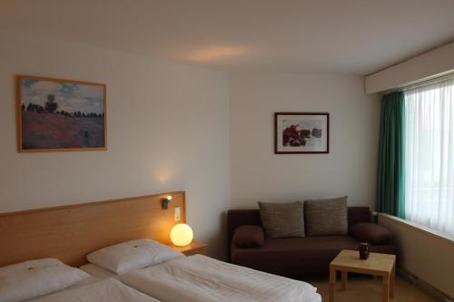 a hotel room with a bed and a couch at Hotel Deisterblick in Bad Nenndorf