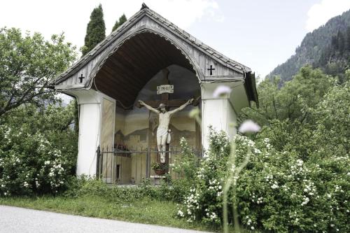a statue of a crucifix on the side of a church at Ferienwohnung Moarhofer in Muhr
