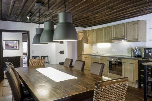 eine Küche mit einem großen Holztisch und Stühlen in der Unterkunft Ferienwohnung Moarhofer in Muhr
