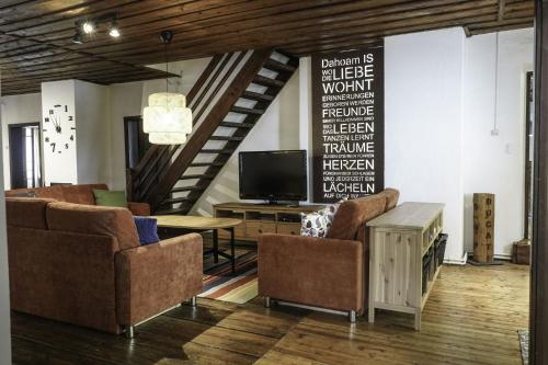 a living room with chairs and a tv and a table at Ferienwohnung Moarhofer in Muhr
