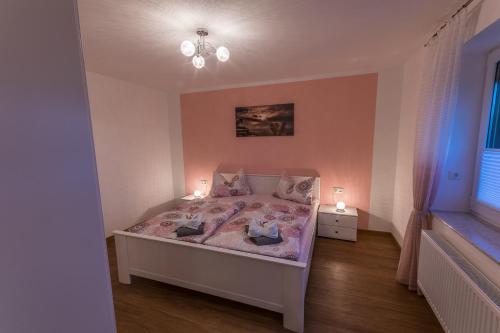 una piccola camera da letto con un letto con due luci sopra di Ferienwohnung "Turmblick" a Rathmannsdorf