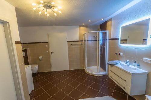 een badkamer met een douche, een wastafel en een toilet bij Ferienwohnung "Turmblick" in Rathmannsdorf